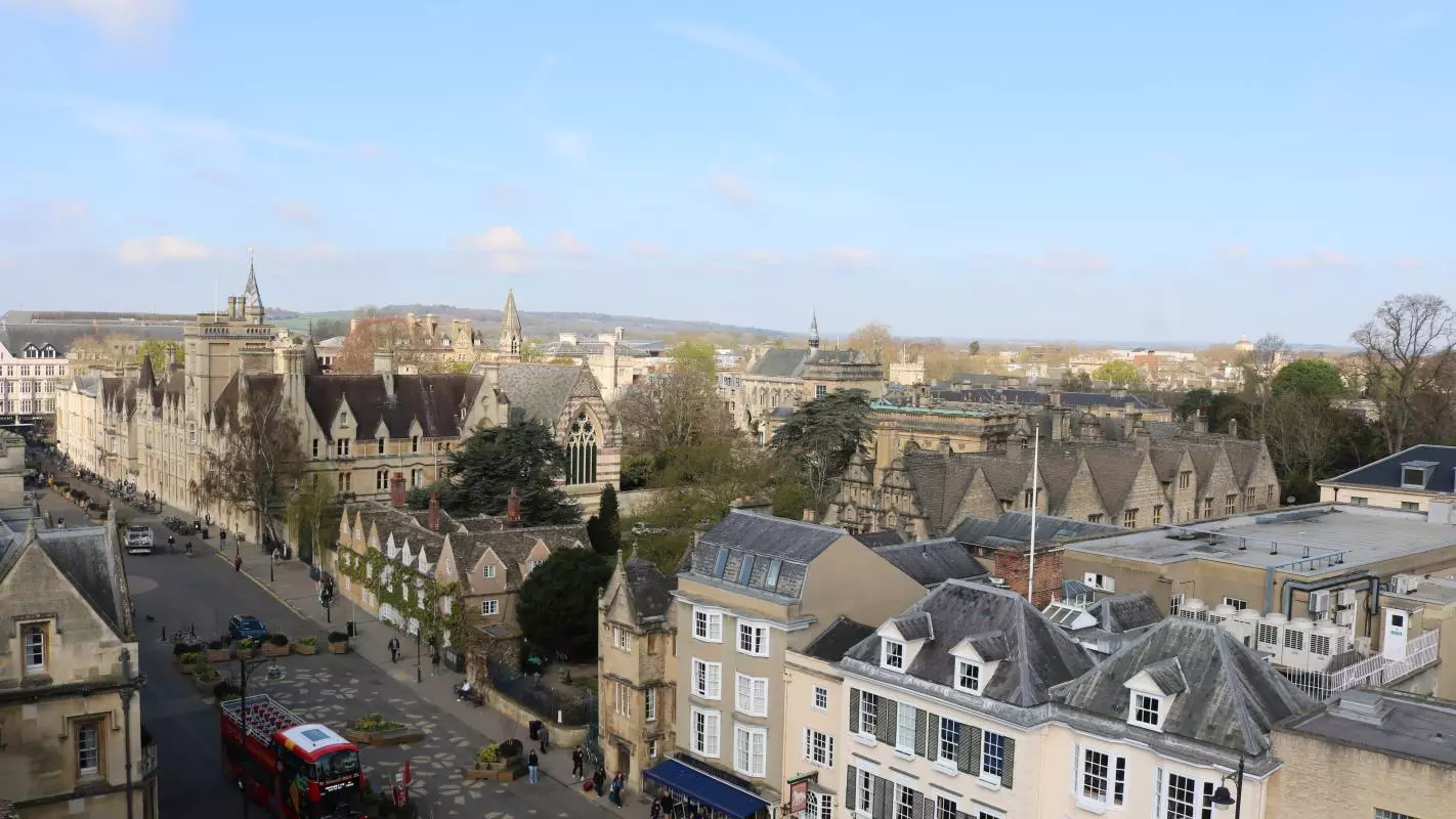A view of Broad Street Oxford from the Sheldonian Theatre's cupola, with fields and hills in the background