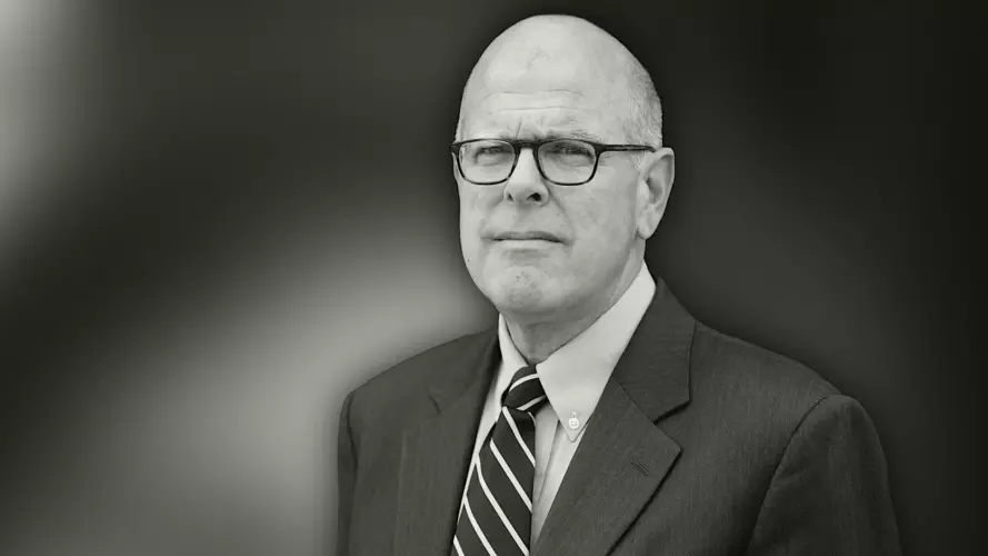 Bald man in glasses looking at the camera in black and white
