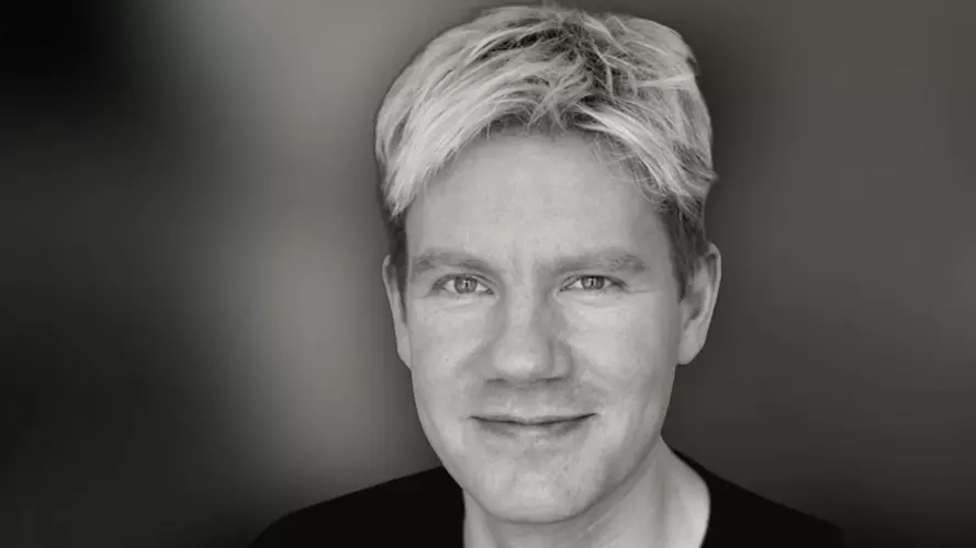 Blonde man staring at the camera in black and white