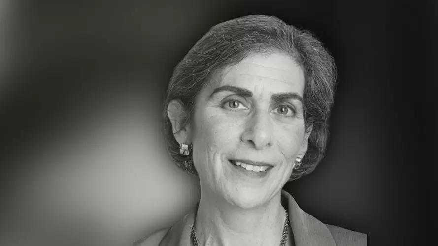 Woman with short hair slightly smiling while looking at the camera in black and white