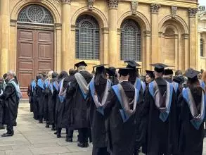 Students queue in their graduation gowns at the South Door of the Sheldonian Theatre