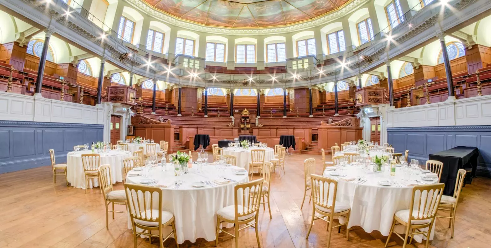 Photo of Sheldonian Theatre with tables and chairs set up for a wedding reception