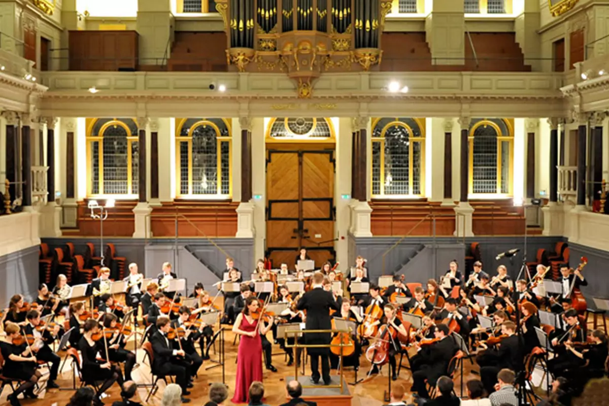 Photo of full orchestra with violin soloist performing a concert in the Sheldonian Theatre